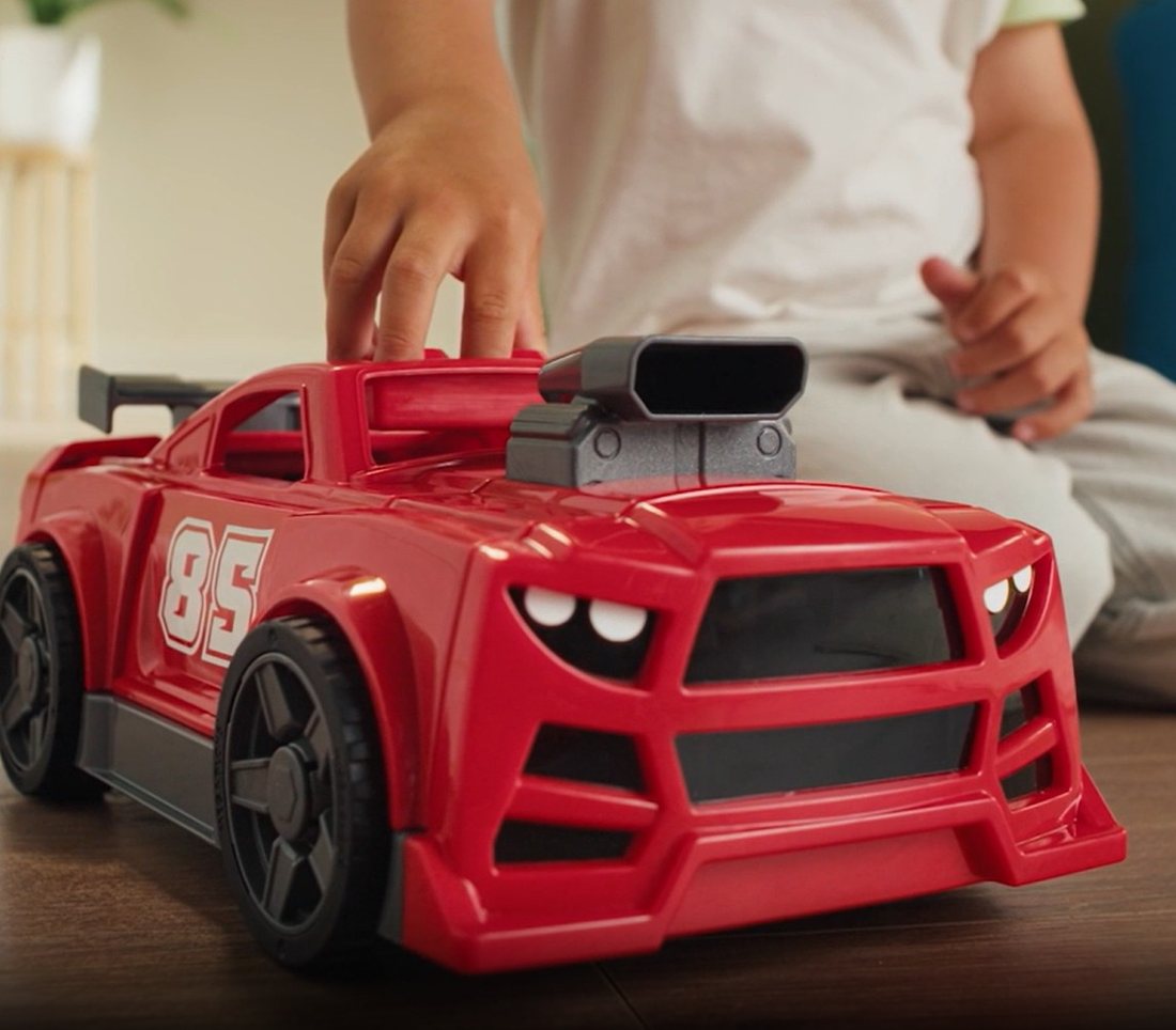 Child's hand on a red MEGA BLOKS Build & Go race car